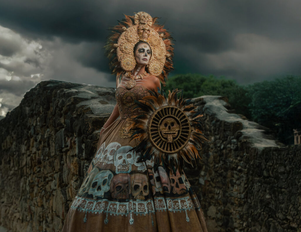 iLaCatrina® icon Mictecacíhuatl represents the Lady of the Dead, ruler of Mictlán alongside her consort Mictlantecuhtli. In Mexica belief, souls destined for Mictlán traveled through nine levels of the underworld over four years before reaching the final realm of the dead.